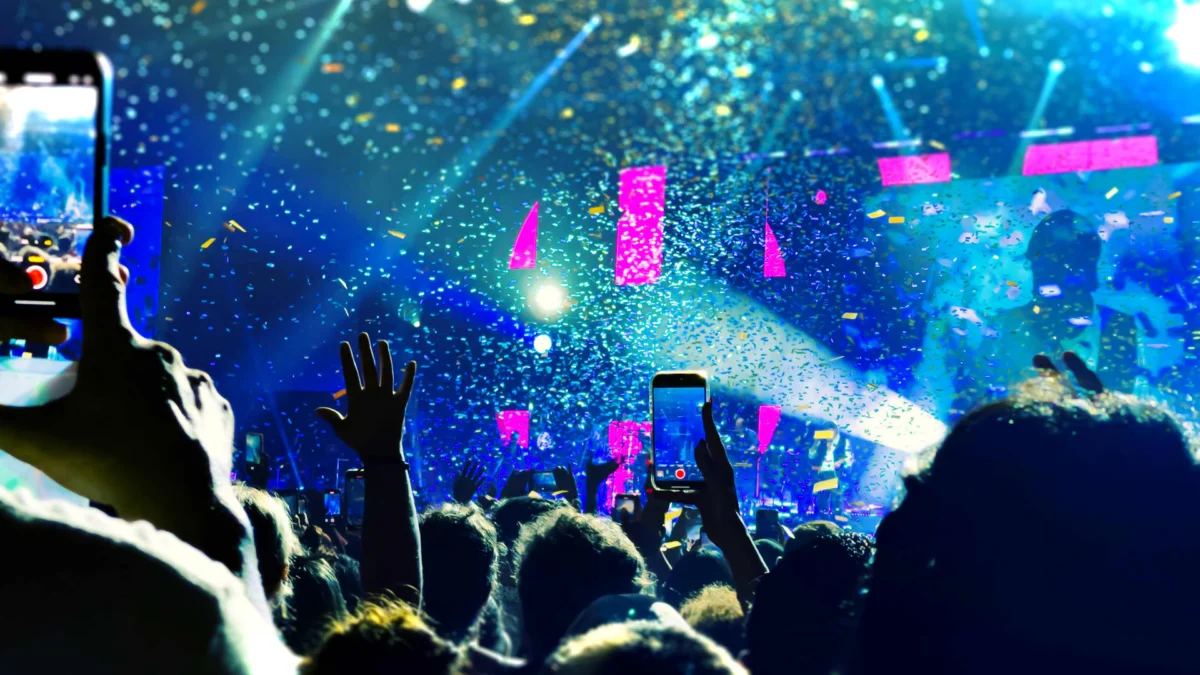A concertgoer holds up a phone displaying a seating chart with available tickets at a venue in New York City.