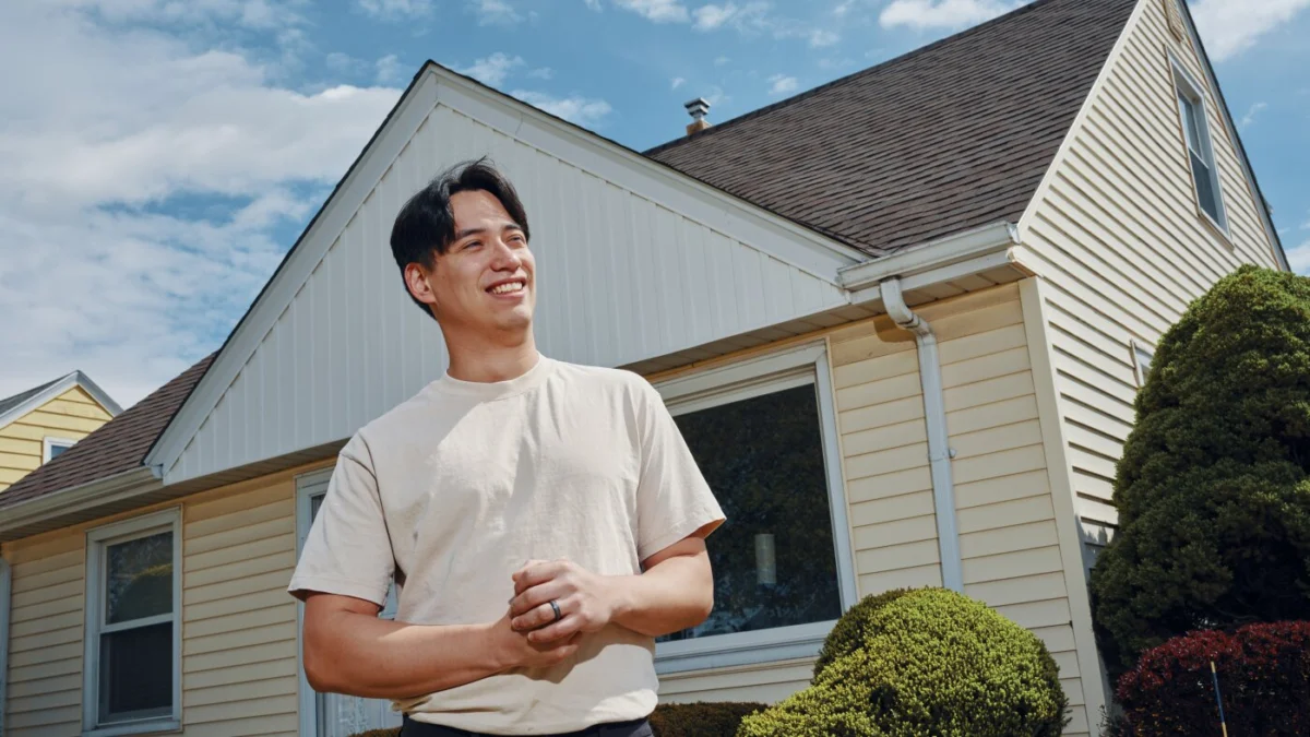 Francisco Vazquez, 27, stands in front of his new home in Milwaukee, Wis., which he purchased for $220,000.