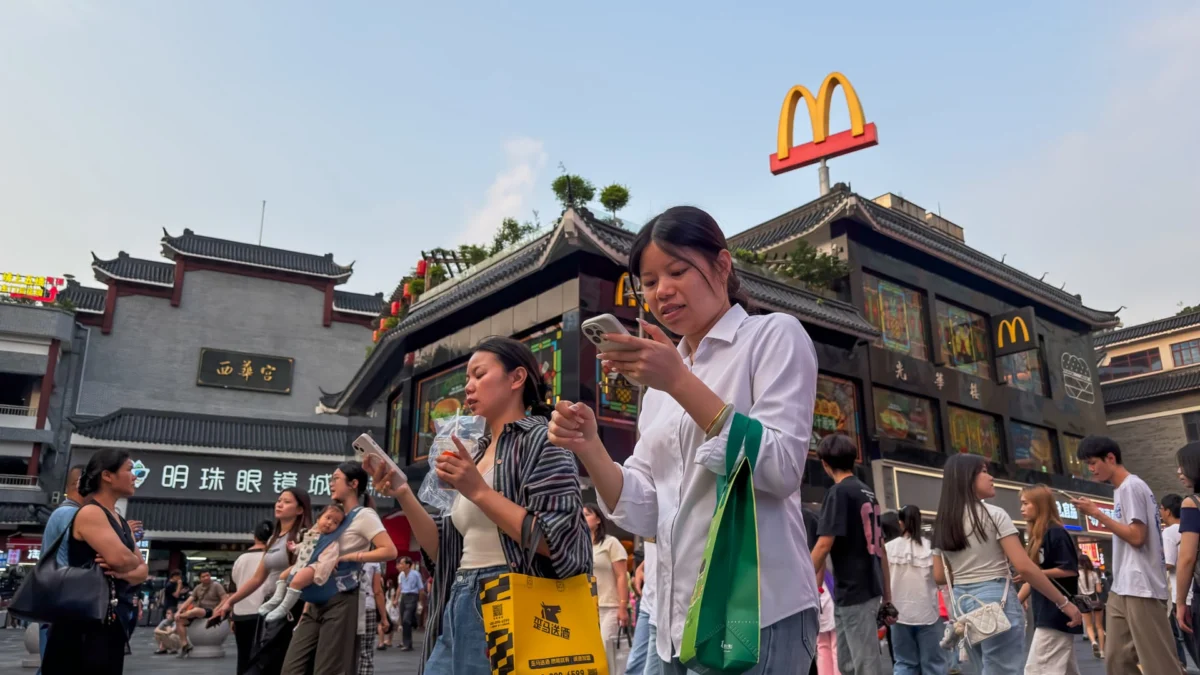 Pedestrians walk past a McDonald's restaurant on a busy street in Shenzhen, Guangdong Province, China.