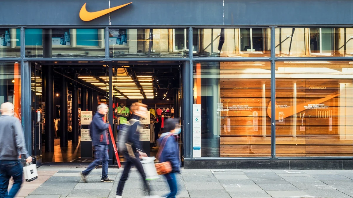 A woman carries a shopping bag while passing in front of a Nike Inc. store in Portland, Ore., April 24, 2013. (Natalie Behring/Bloomberg via Getty Images / Getty Images)