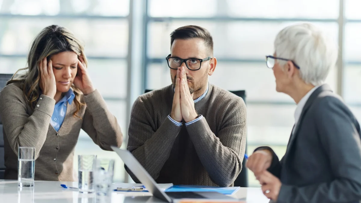 Displeased couple having problems during a meeting with their agent in the office.