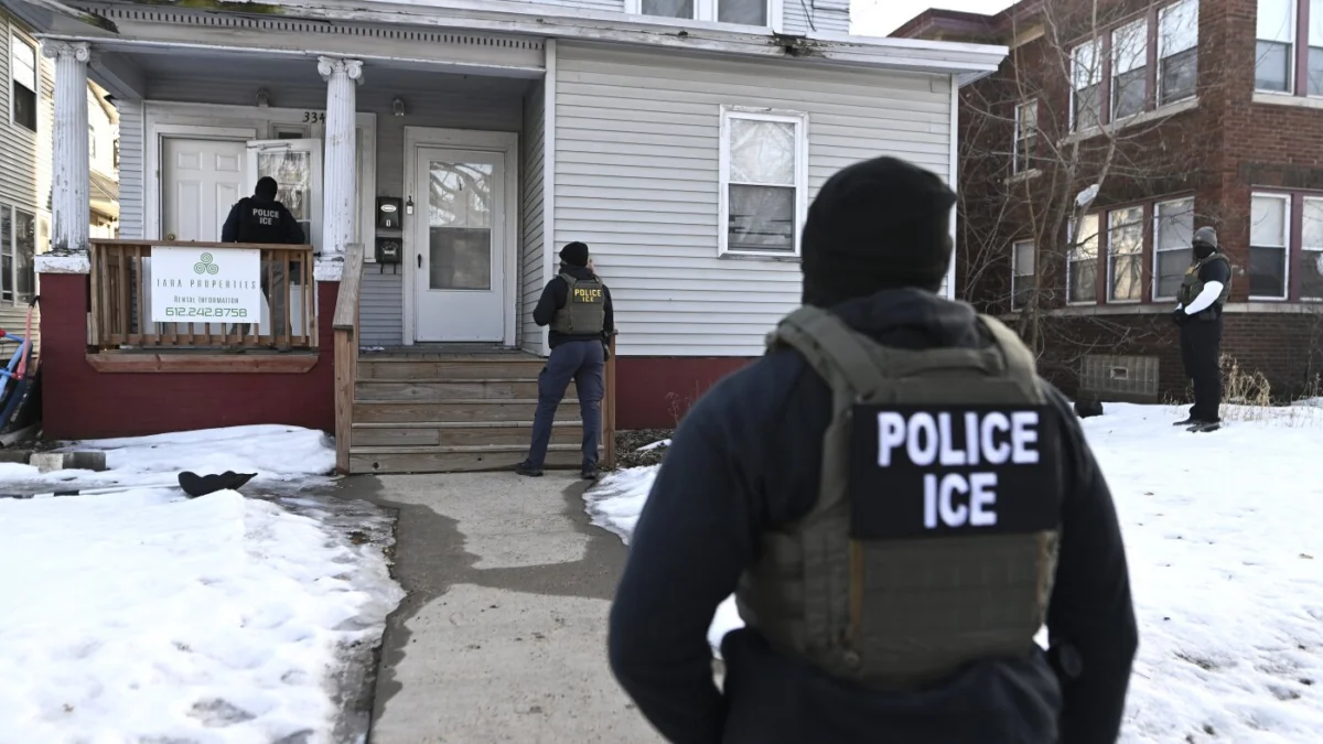 ICE agents approach a house before detaining two people on Jan. 13 in Minneapolis. Stephen Maturen/Getty Images