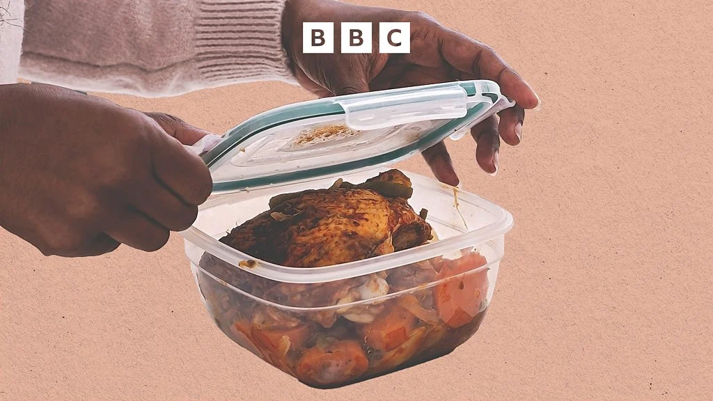 A woman opens a food container filled with chicken and vegetables, illustrating the concept of meal preparation.