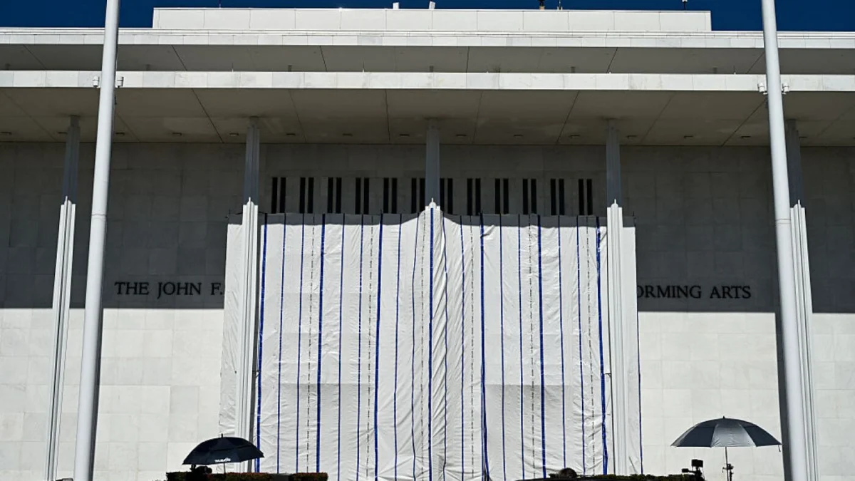 Workers remove President Trump’s name from the Kennedy Center façade after court-ordered deadline.