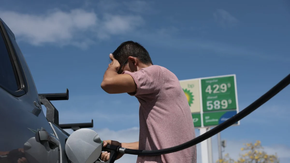 A gas station sign shows fluctuating prices as consumers face volatile fuel costs.