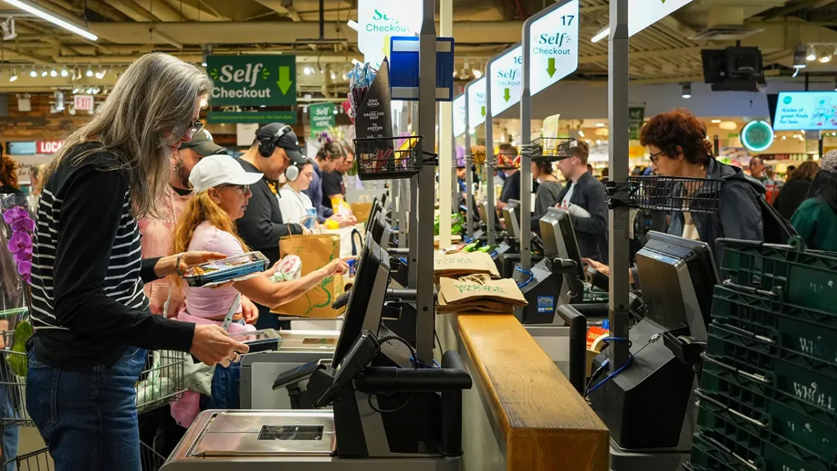A shopper at a grocery store amid rising food costs, highlighting the strain on household budgets.